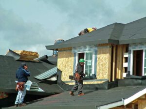 Homeowner reviews a roofing contract beside roof inspection photos and a calculator.